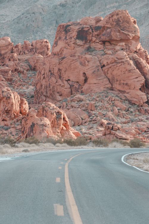 Free Narrow asphalt roadway leading to red rocky formations in canyon in daylight in nature in mountainous area in summer day Stock Photo