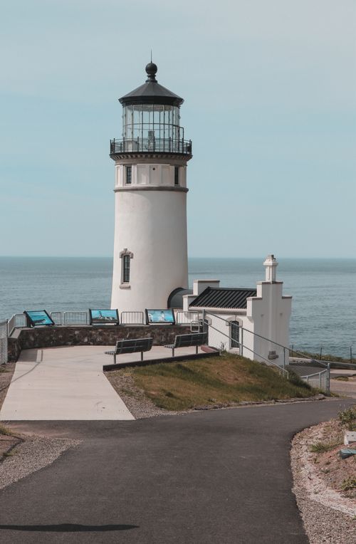 Free A stunning view of Cape Disappointment Lighthouse against the ocean and clear sky. Stock Photo