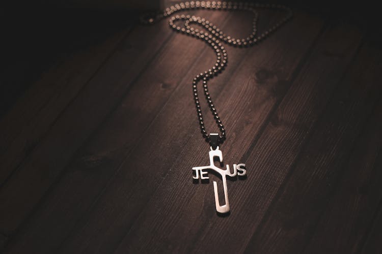 Necklace With Cross Pendant On Wooden Table