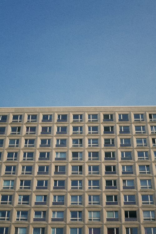 Free Vertical shot of modern architecture with glass windows against a clear blue sky. Stock Photo