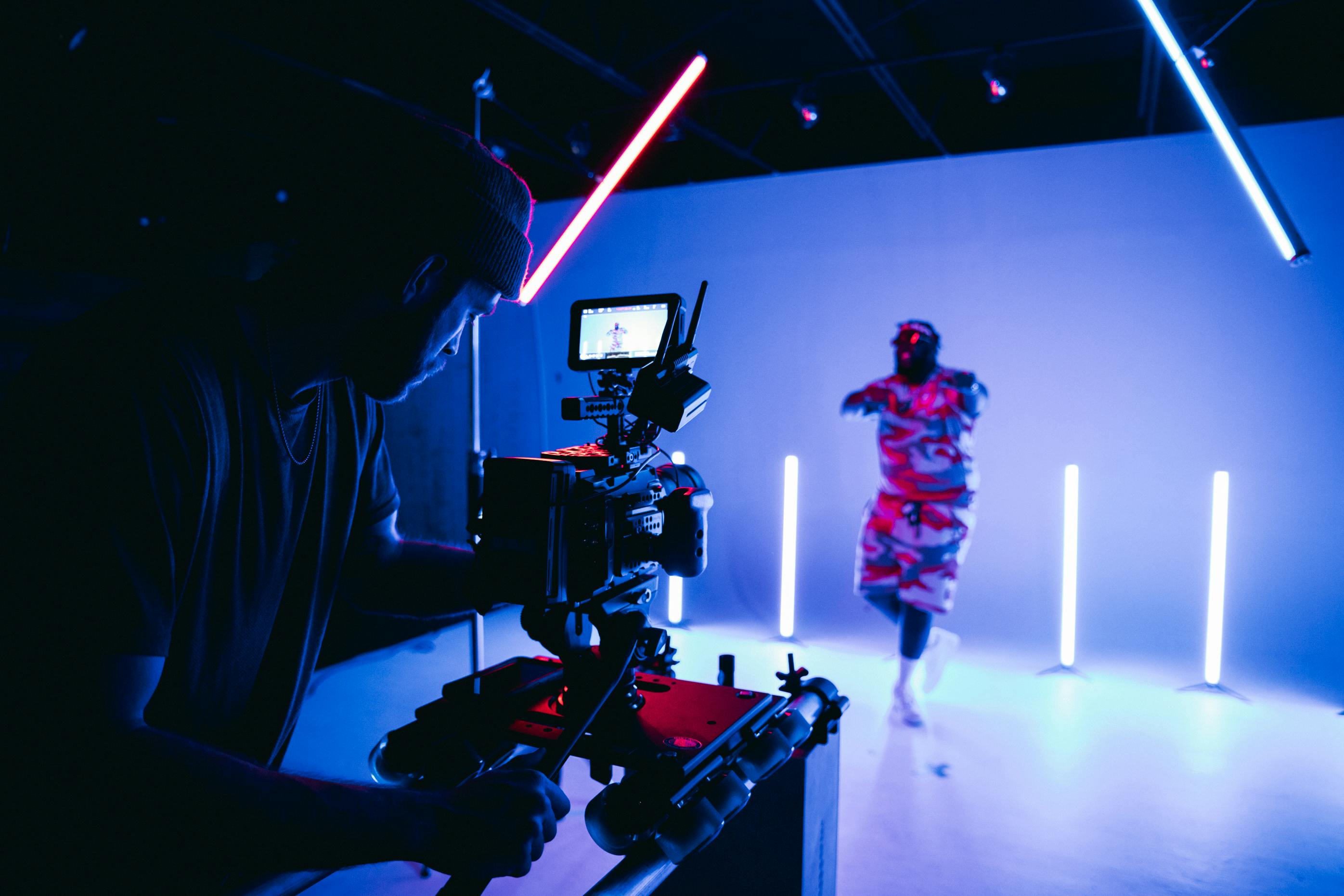 A person recording lights and a model using a video camera