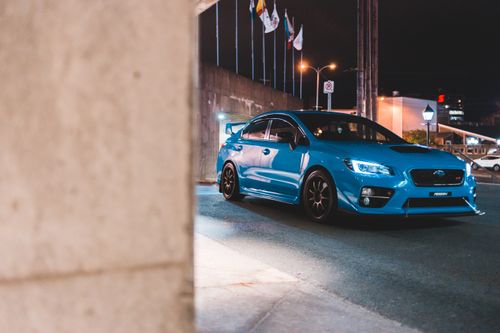 Free Contemporary luxury blue automobile with shiny headlights on asphalt roadway near government building in twilight Stock Photo