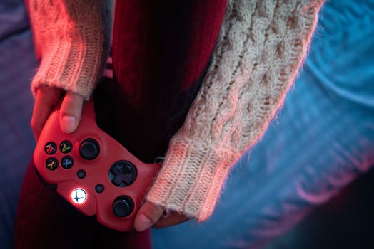 Close-up of hands holding a red gaming controller, creating a cozy gaming vibe.
