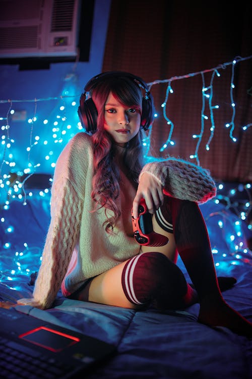 Woman in Beige Knit Sweater Sitting on Bed