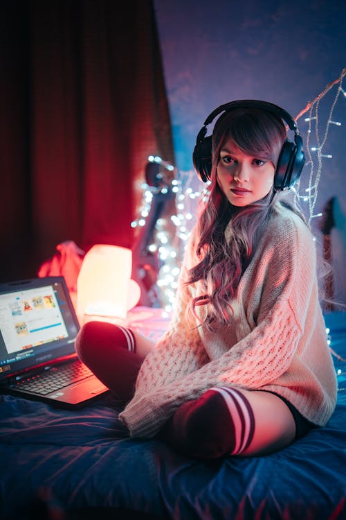 Free A Gamer Sitting on a Bed  Stock Photo