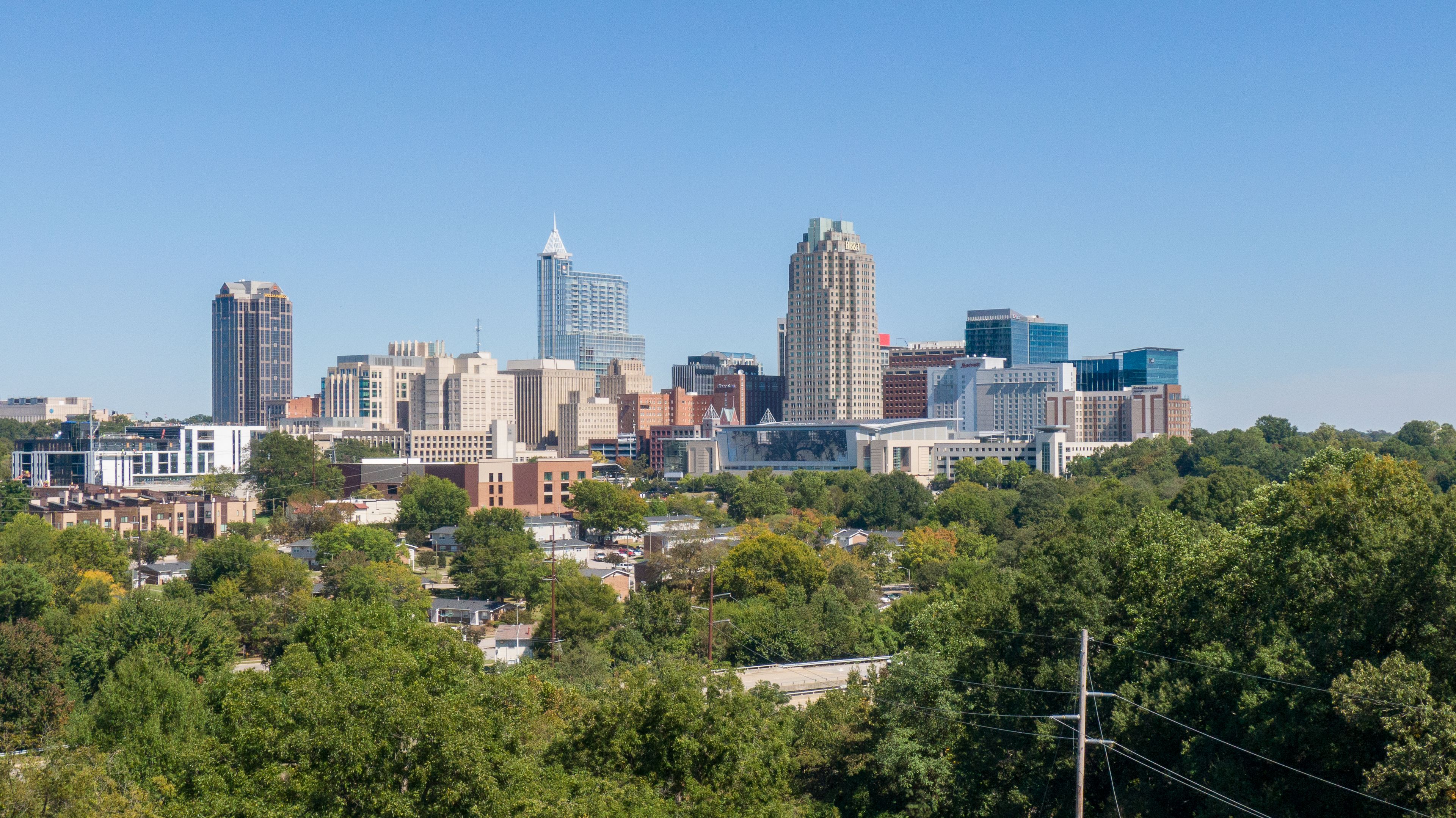 Fuquay-Varina: Raleigh skyline above green trees