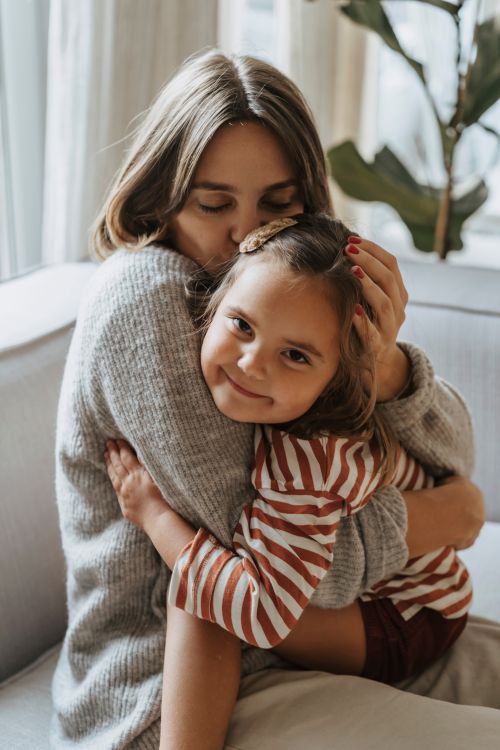 Free A warm embrace between a mother and daughter indoors symbolizing love and family bonds. Stock Photo