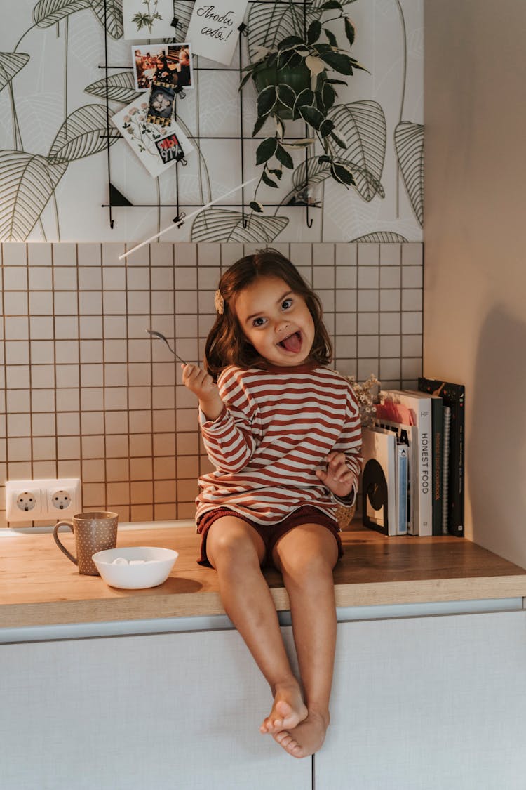 Cute Girl With Her Tongue Out Holding A Spoon 