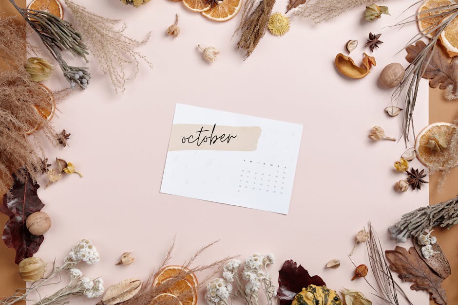 How Notion Solves Weekly YouTube Upload Planning October calendar surrounded by autumn leaves and dried plants in a flat lay arrangement.