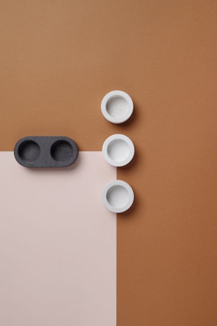 A minimalist flat lay showcasing ceramic bowls on a geometric brown surface, perfect for conceptual and still life themes.