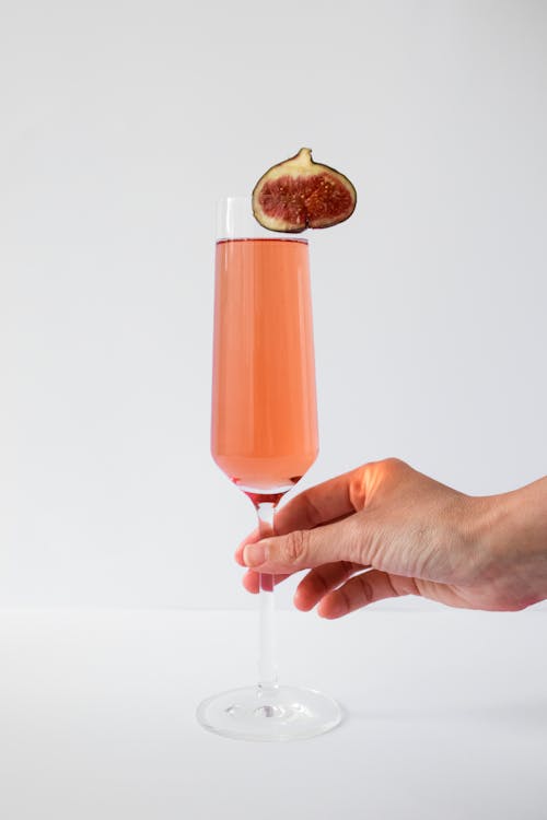 Person Holding a Champagne Glass with Pink Liquid 