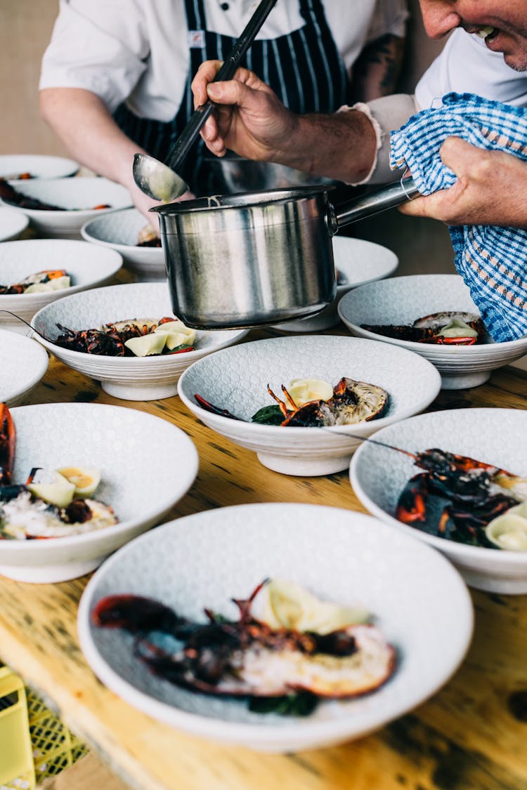 Crop Chefs Serving Lobsters In Restaurant