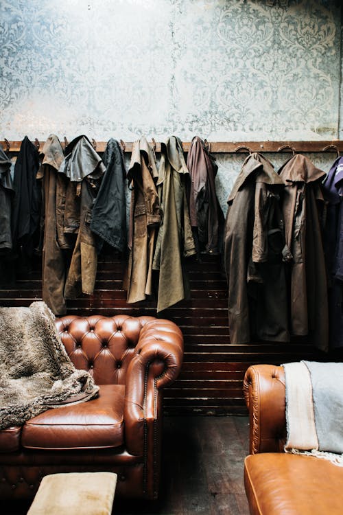 Clothes hanging on wall in vintage styled studio with sofas