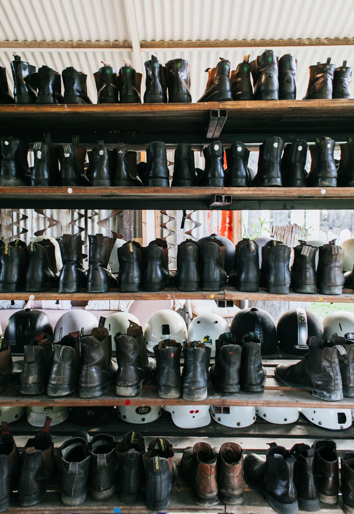 Old-fashioned leather boots arranged on wooden shelves in a vintage setting