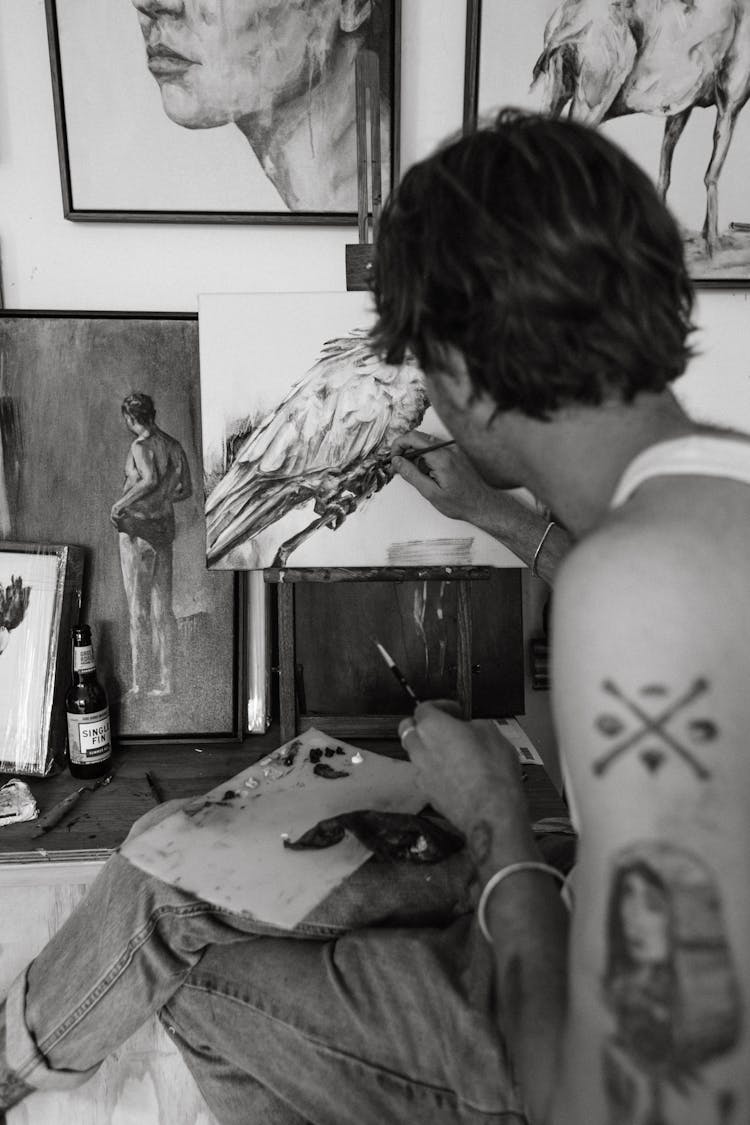 Calm Young Tattooed Guy Drawing Picture In Art Studio