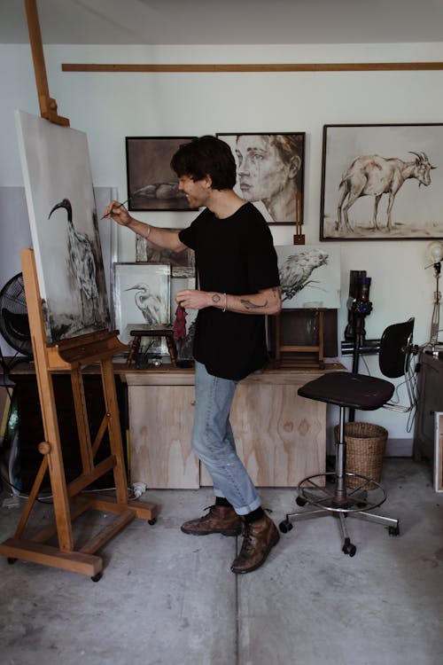 Man painting on easel in workshop