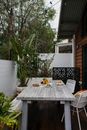 Wooden table with chairs places on terrace of residential house in countryside in daytime