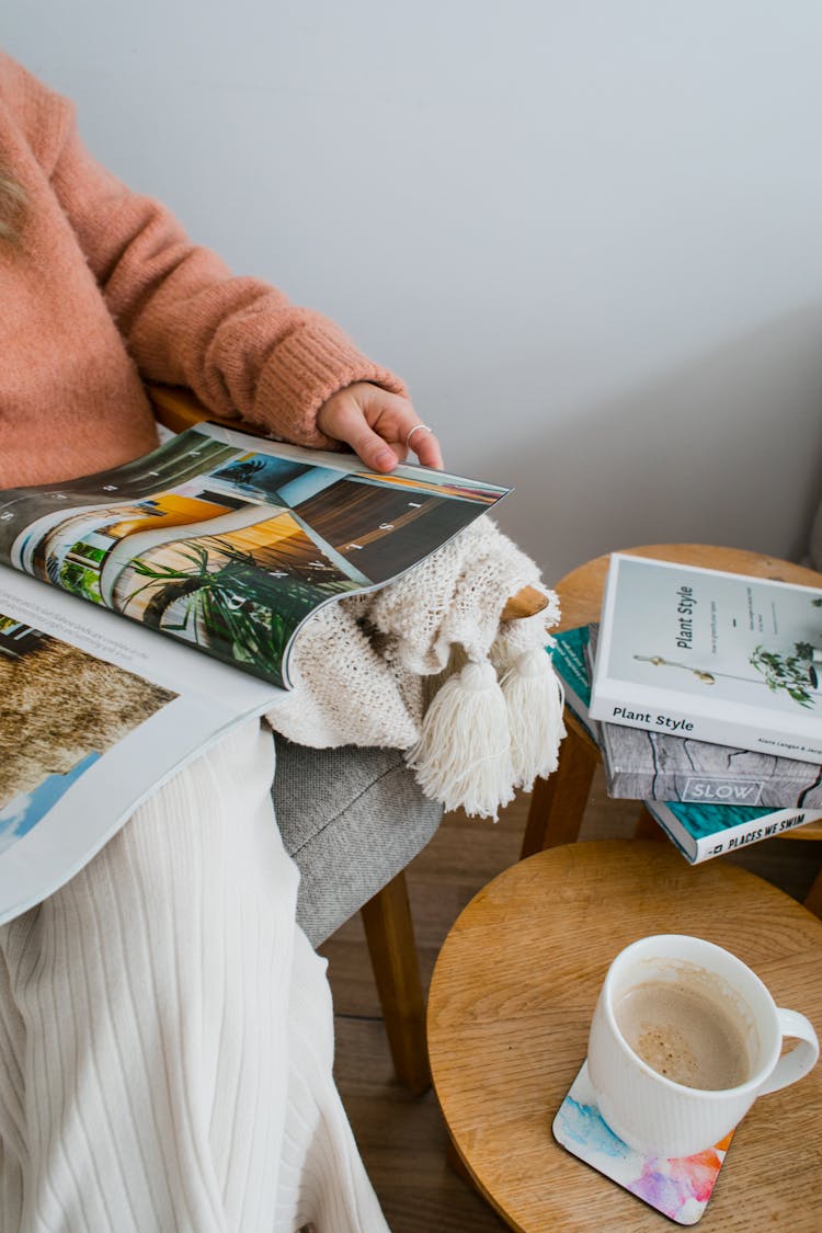 Crop Woman Reading Magazine And Drinking Coffee At Home