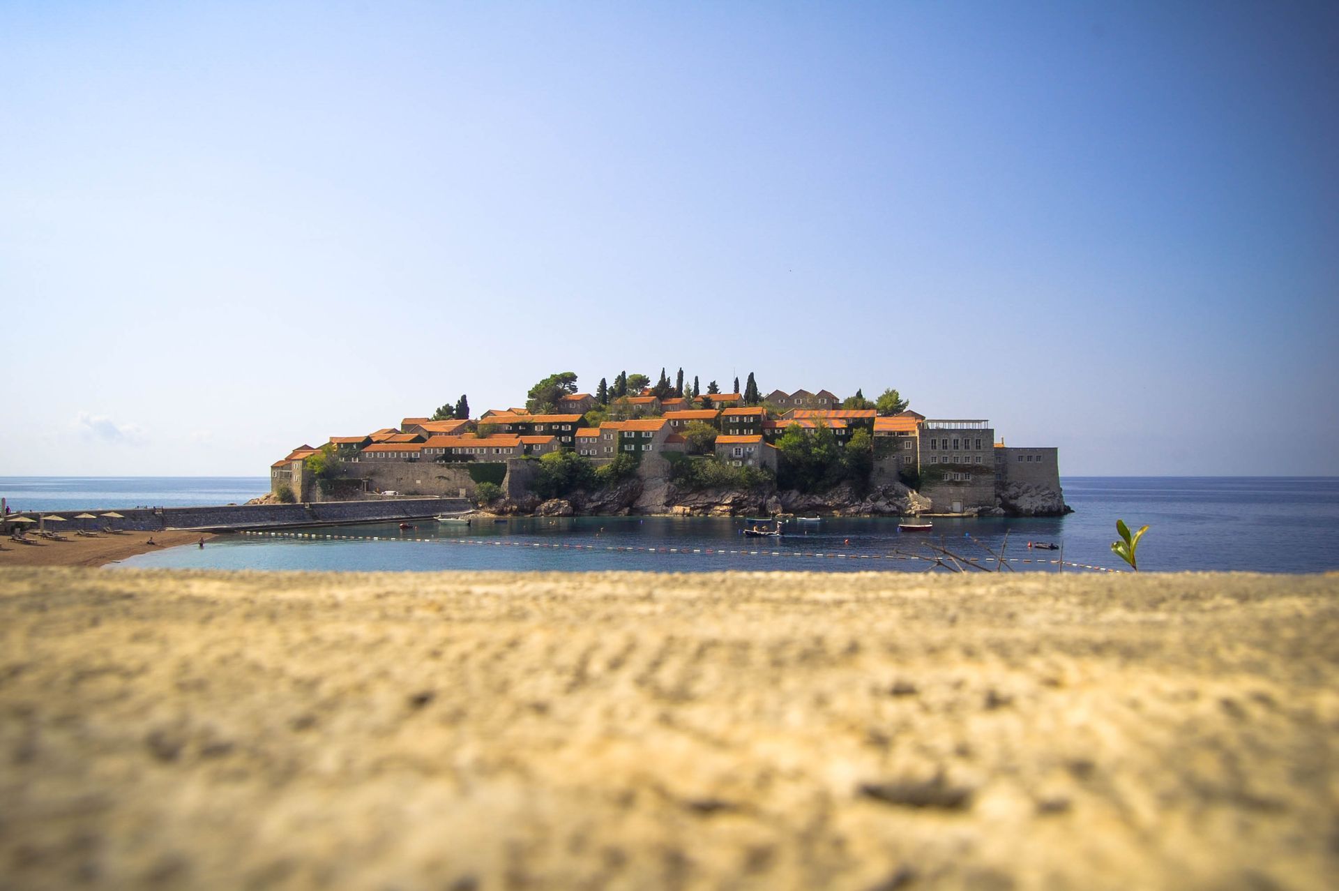 Picturesque Sveti Stefan island resort in Montenegro, captured on a sunny summer day.
