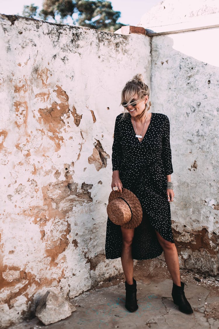 Happy Stylish Woman Standing Near Grunge Wall