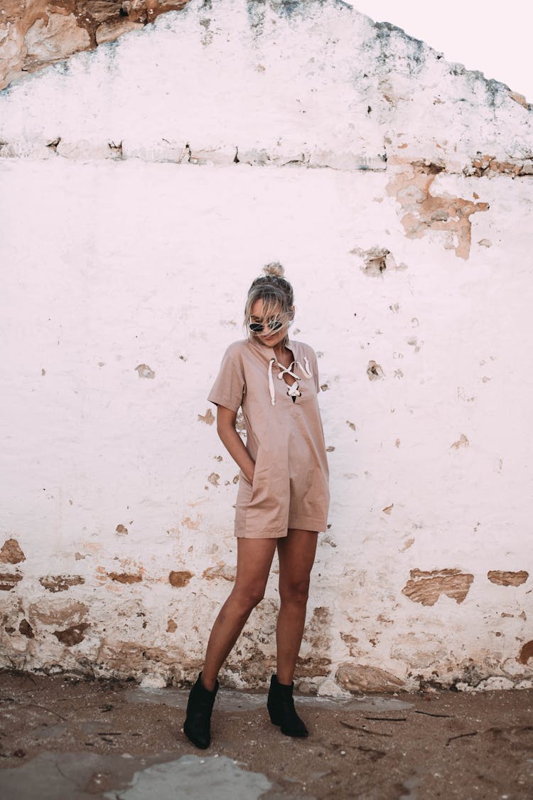 Woman In Trendy Clothes Near Shabby Concrete Building