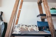 Stack of clean cotton towels with tassels placed on shelf at home in daytime