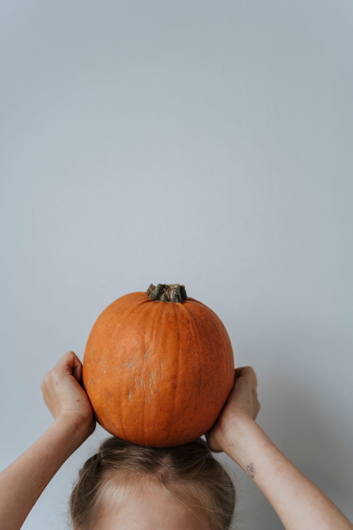 Child playing with a Halloween pumpkin