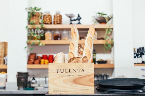 Free Tasty fragrant baguettes and bread placed in timber box on counter of modern cafe on blurred background Stock Photo