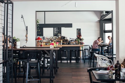 Contemporary cafe with simple interior and people resting and having lunch at tables