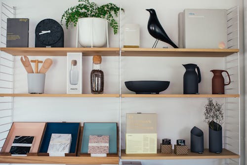 Wooden shelves decorated with different vases and jugs with statue