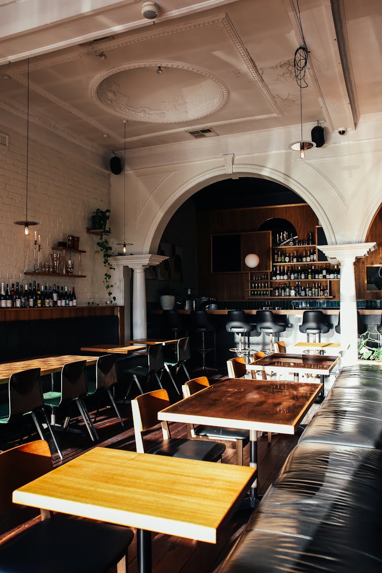 Classic Styled Restaurant Interior With Wooden Furniture And Bar Counter