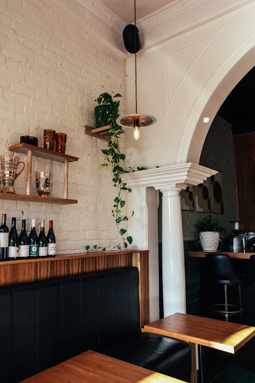 Interior details of modern bar with wooden furniture and arched wall