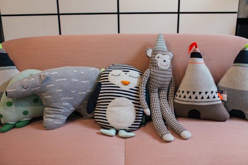 Free Collection of various soft toys placed in row on comfortable sofa in modern apartment Stock Photo