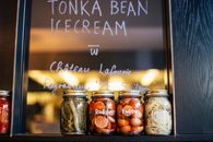 Jars with various pickled vegetables on shelf in cafe