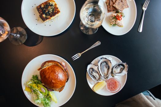 Plates with burger and pie neat crackers and mussels