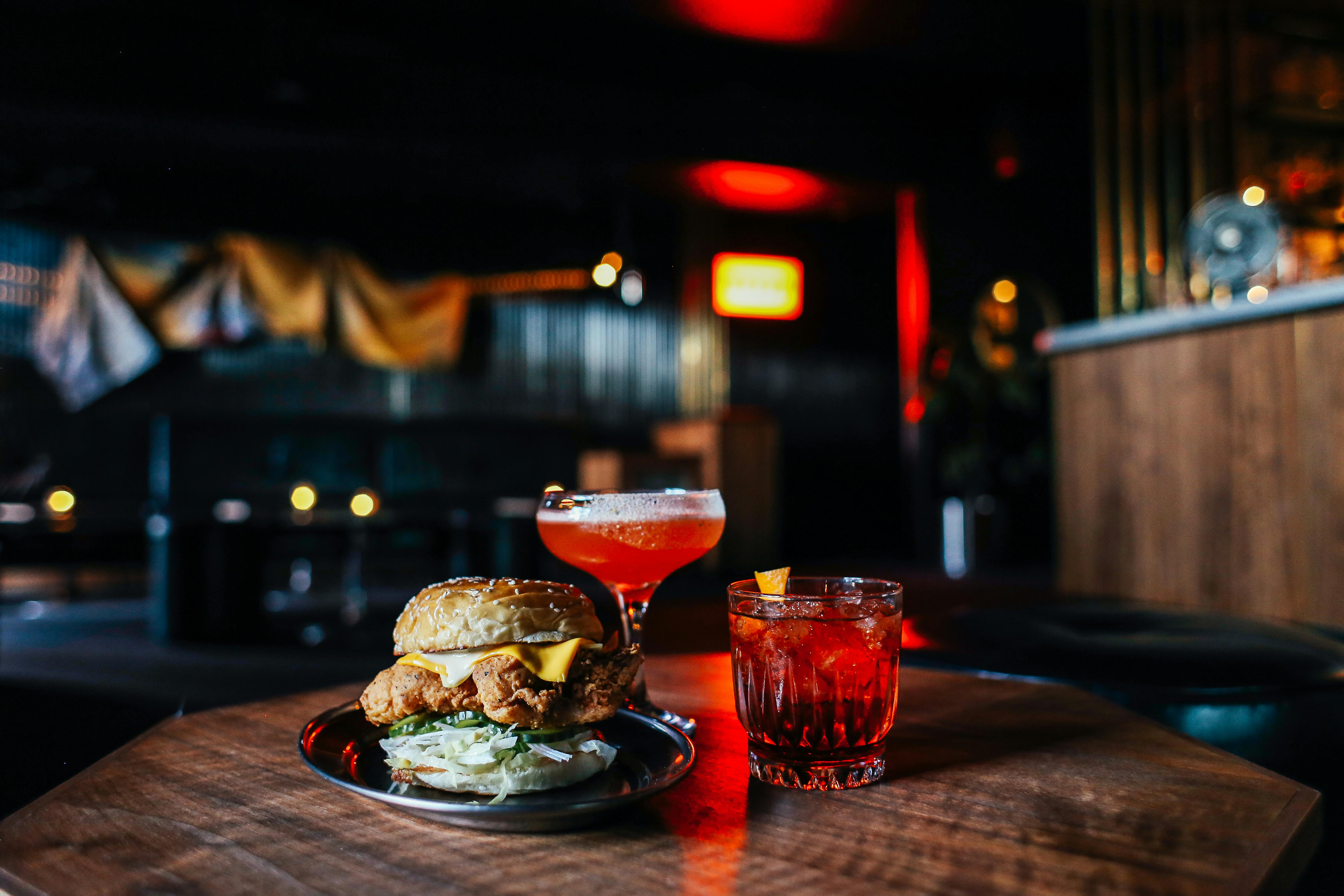 delicious hamburger with cocktails on table