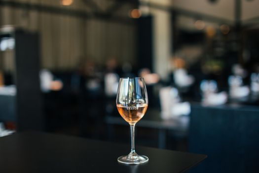 一张别致的现代餐桌上，摆放着盛有玫瑰酒的酒杯，营造出奢华的氛围