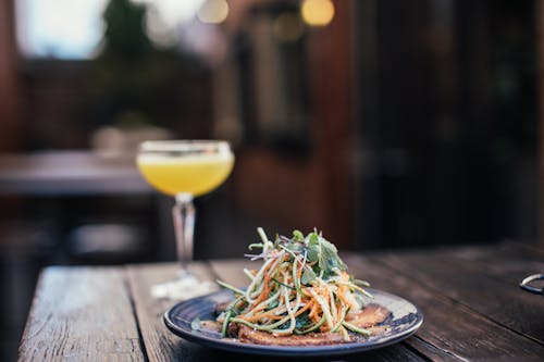 Delicious noodle salad with cocktail in bar