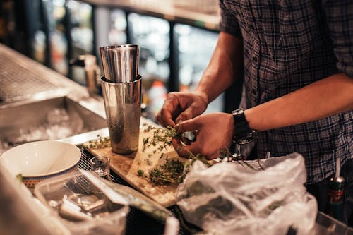 Crop barman preparing herbs for cocktail