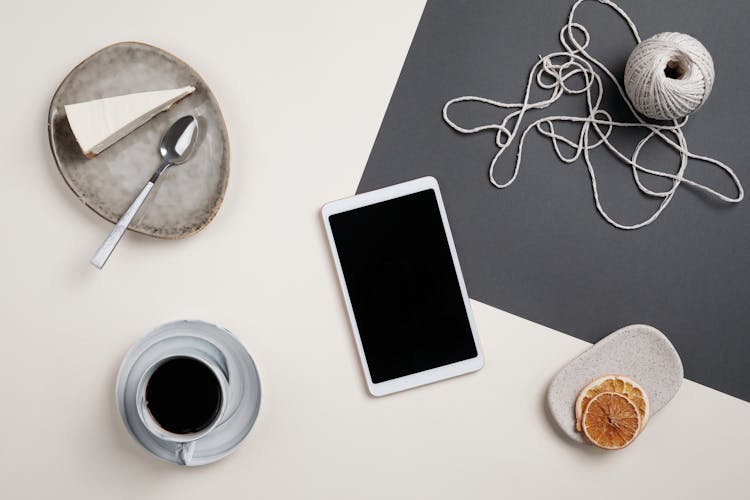 A Ball Of Yarn And An Ipad Beside The Food And The Coffee