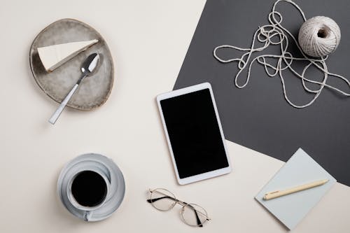 Coffee and Cake on the White Surface with Digital Tablet and Yarn Roll