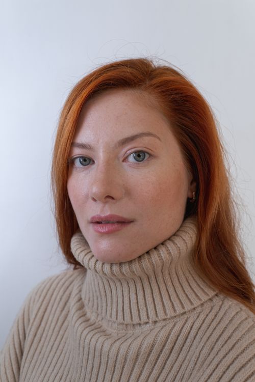 Free Casual portrait of a redheaded woman in a beige turtleneck showcasing natural beauty. Stock Photo