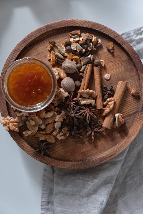 Walnuts and Cinnamon Sticks on a Brown Wooden Tray