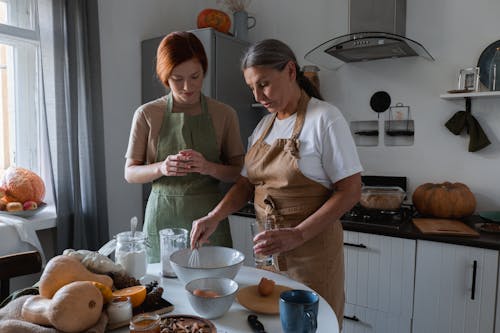 Elderly Woman Wearing Brown Apron Holding a Whisk