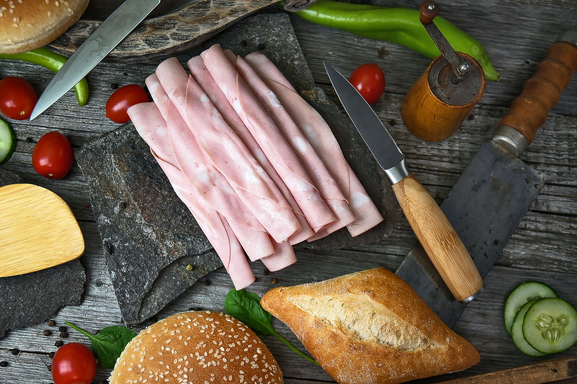 Slices of Boars Head beef bologna on a wooden cutting board