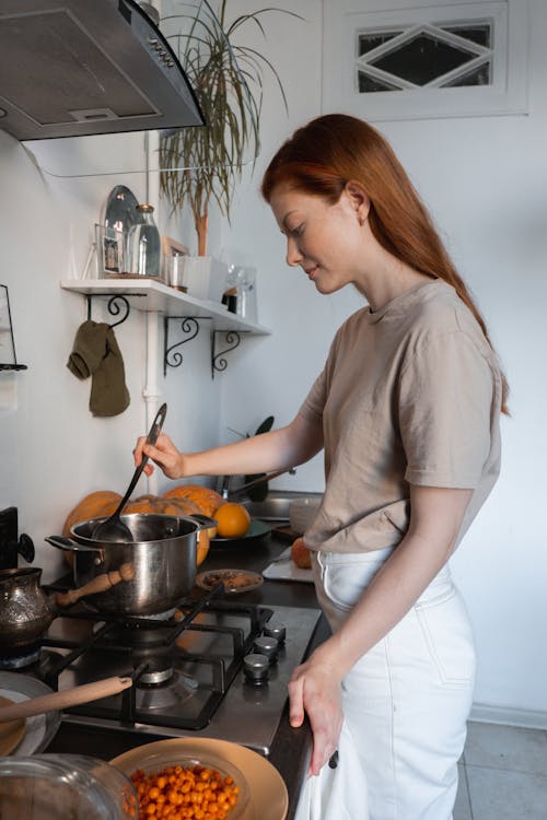 Free Woman in White Shirt Holding Stainless Steel Cooking Pot Stock Photo