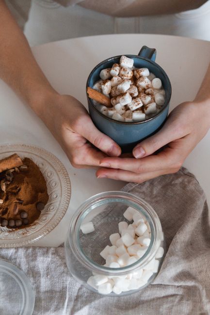 Close-up of a warm mug of hot chocolate topped with marshmallows and cinnamon, perfect for winter comfort.