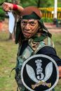 Man in Green and Brown Camouflage Jacket Wearing Black Hat