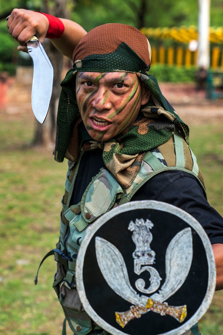 Man In An Army Uniform Holding A Shield And A Knife