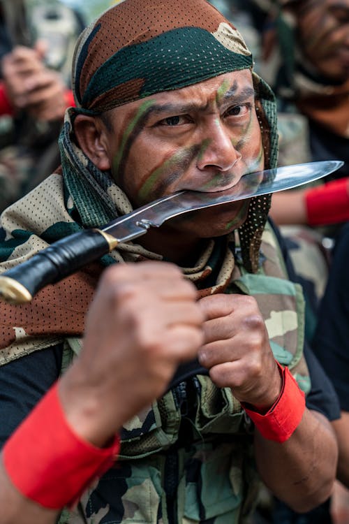 Portrait of Military Man with Knife in Mouth